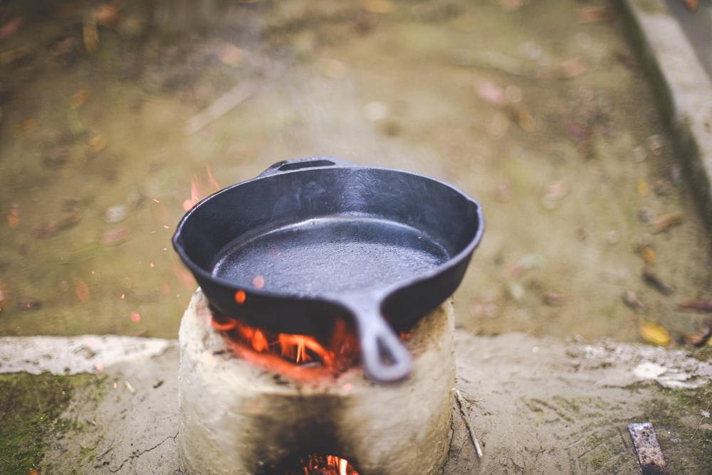 a cast iron skillet sitting on top of a fire pit