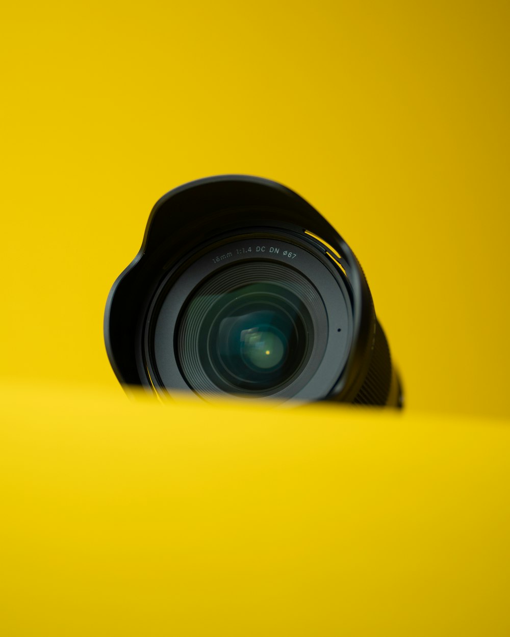 uma lente de câmera sentada em cima de uma superfície amarela