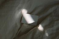 A blank page with a soft natural light casting gentle shadows across it.