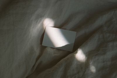 A close-up of a blank sheet of paper on a wooden desk under soft morning light.