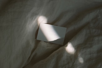 A close-up of a blank sheet of paper on a wooden desk under soft morning light.