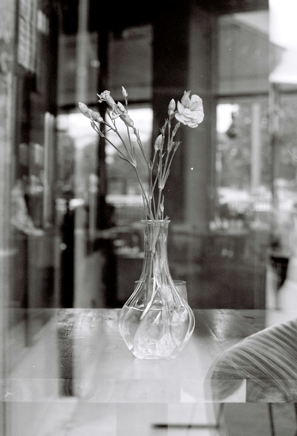 a black and white photo of a vase with flowers in it