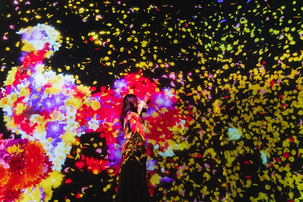 a woman standing in front of a large display of flowers