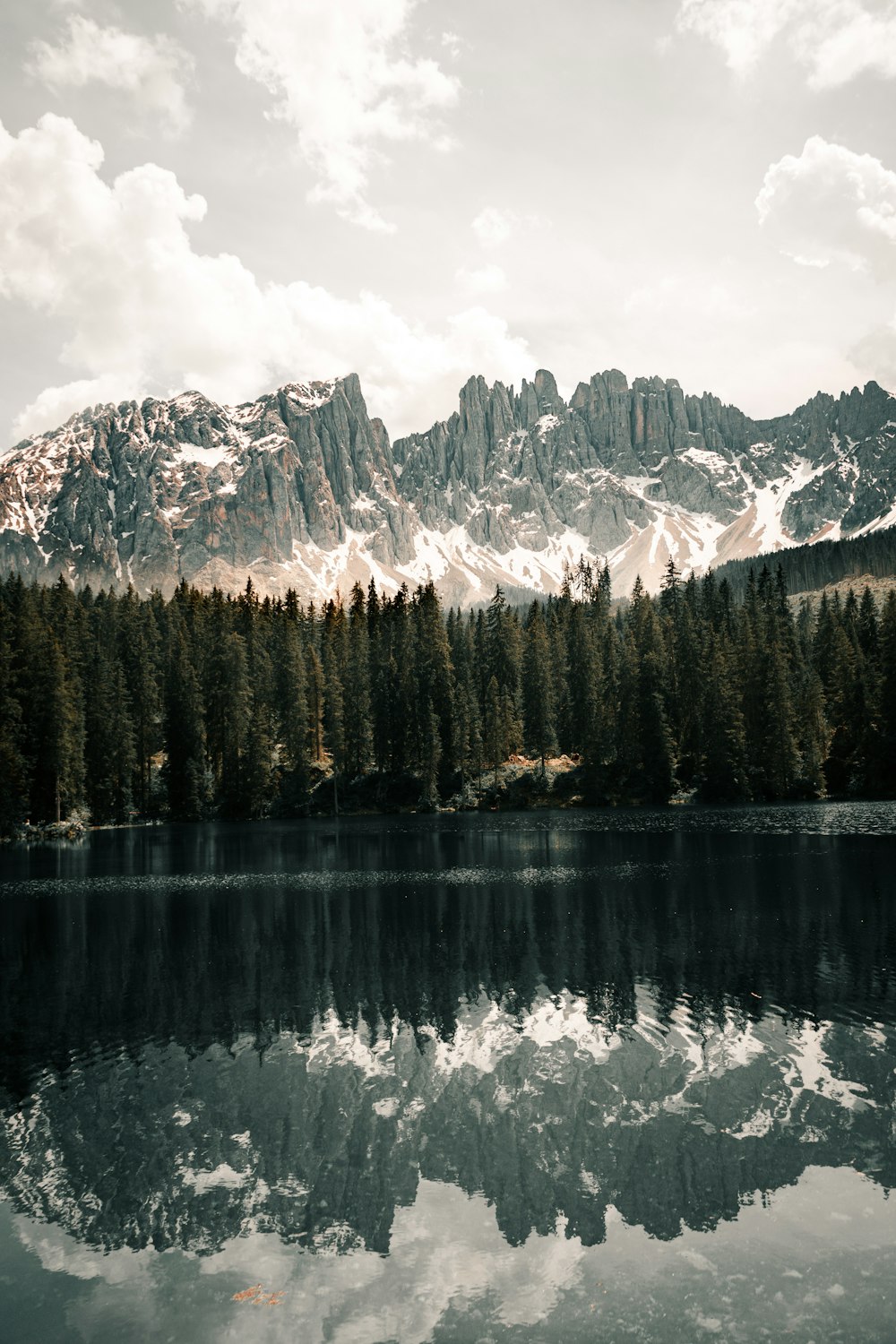 Una catena montuosa si riflette nell'acqua ferma di un lago