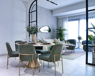 Modern dining area with green chairs and elegant table.
