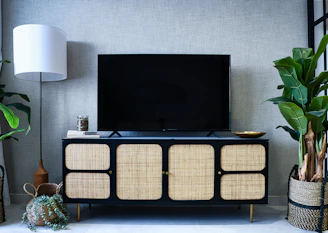 Modern media console with woven doors and a large television.