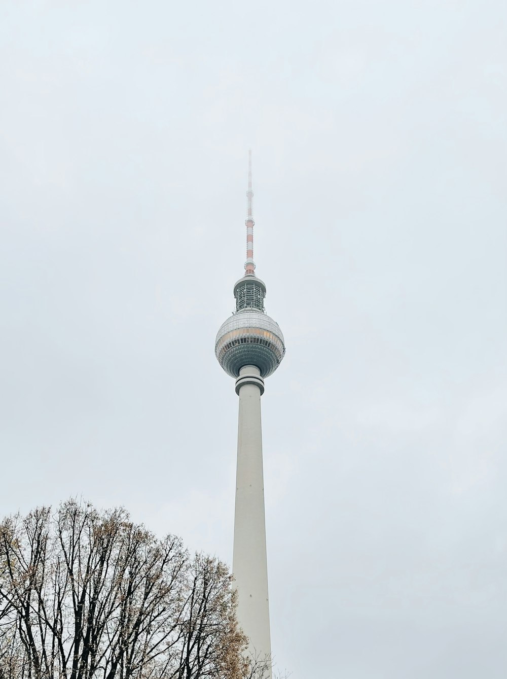 a tall white tower with a clock on it's side