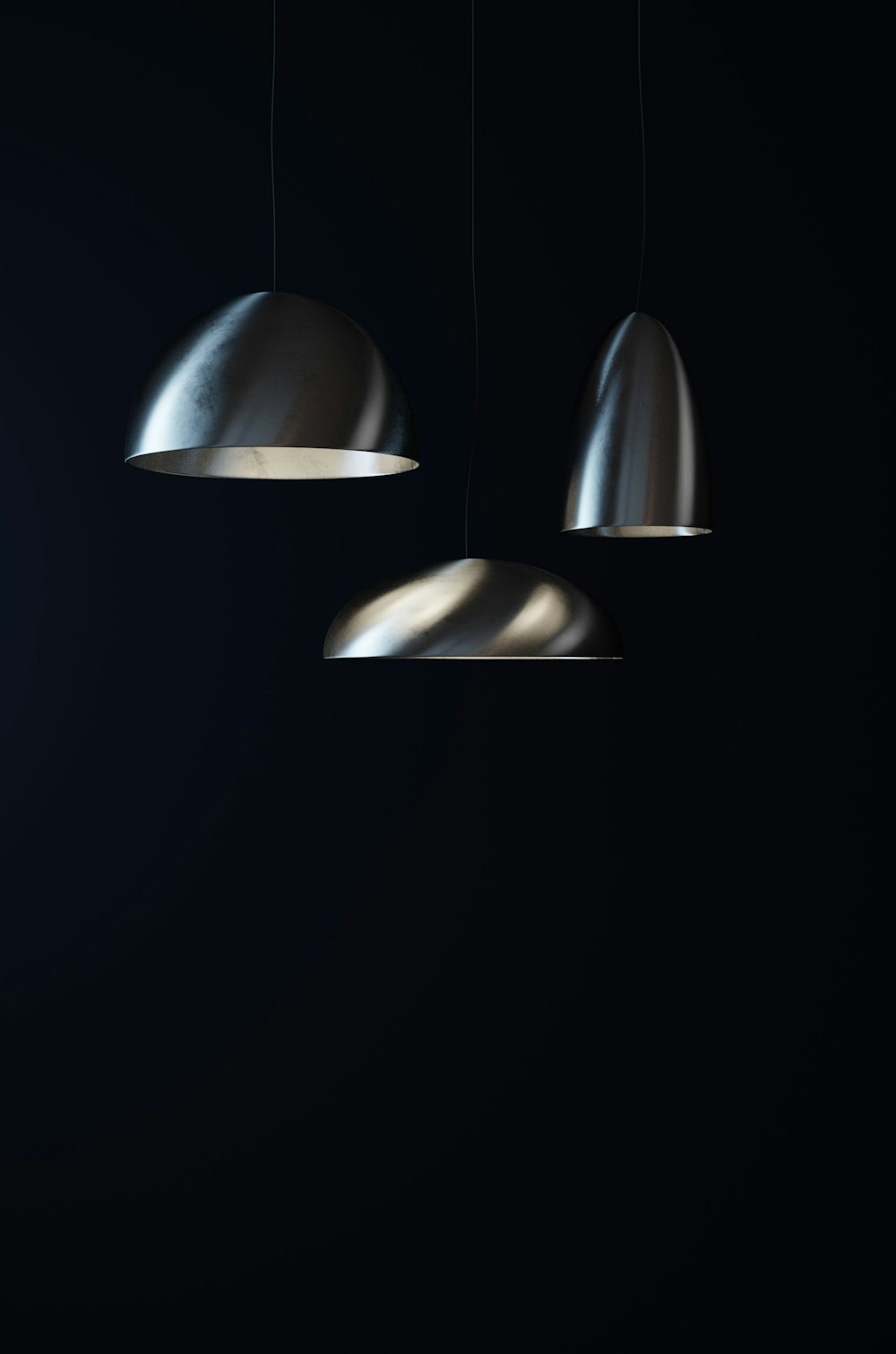 three lights hanging from a ceiling in a dark room