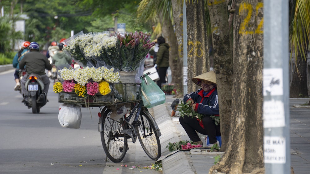 Eine Person auf einem Fahrrad mit einem Korb voller Blumen