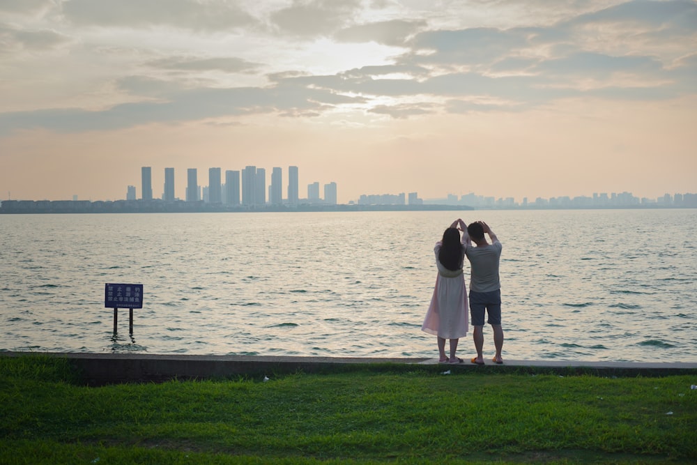 a couple of people standing on top of a lush green field