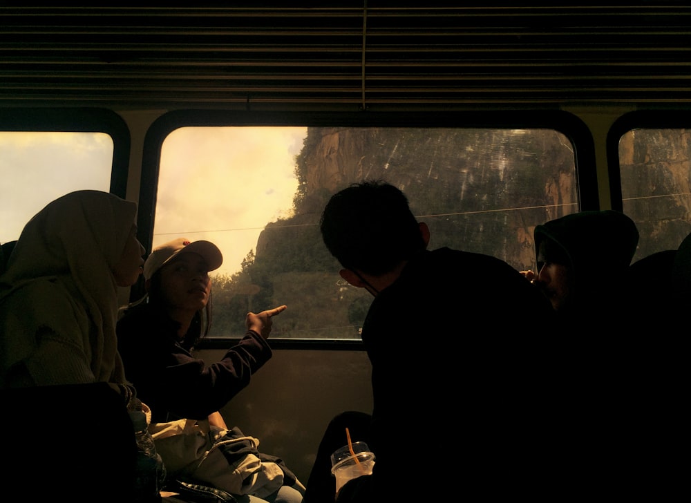 un groupe de personnes assises dans un bus les unes à côté des autres