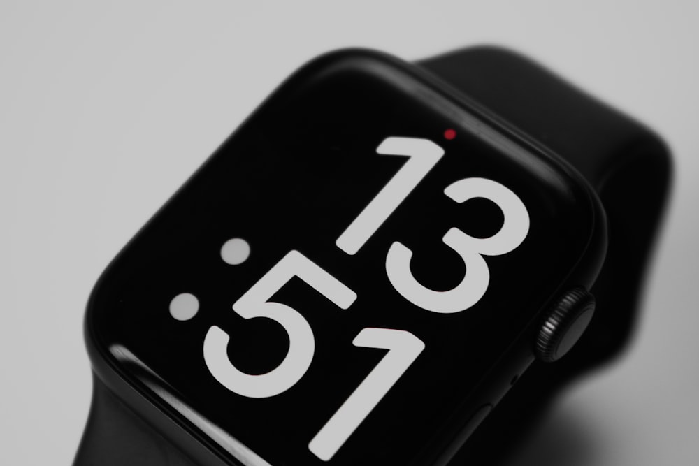 a close up of a black apple watch with white numbers