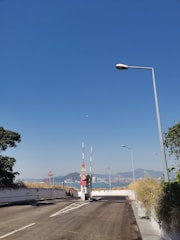 A sturdy boom gate installed at a residential estate entrance under a clear blue sky.