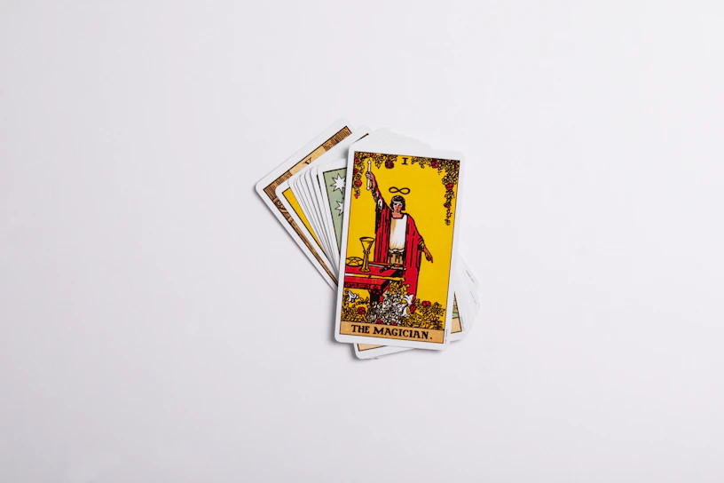 Close-up of the intricate artwork on the Tarot card 'The Magician' glowing softly against a dark background.
