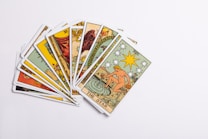 A collection of tarot cards spread out, with the card depicting 'The Star' prominently displayed on top. The cards feature intricate and colorful illustrations with various symbols and figures.