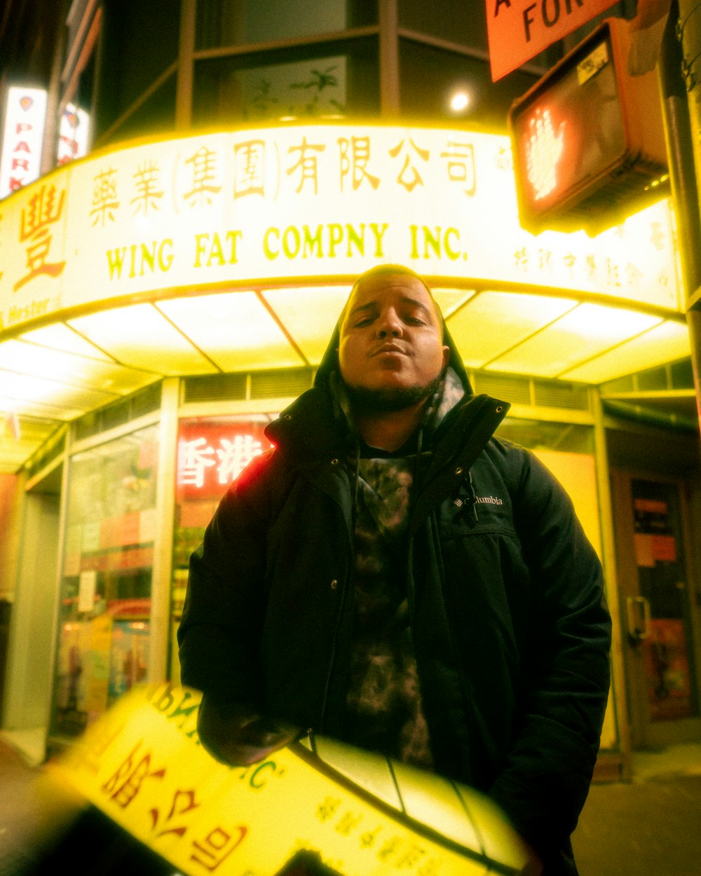 a man standing in front of a building at night