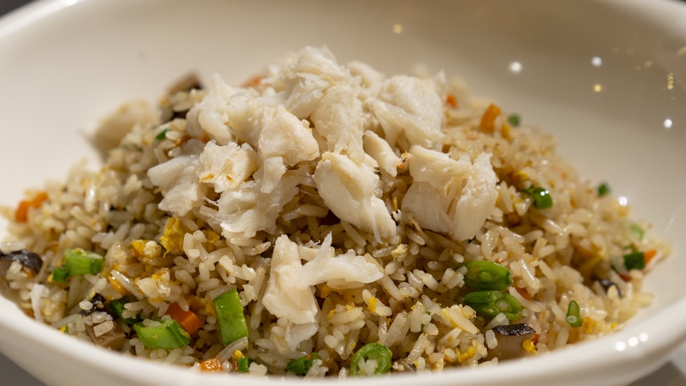 a white bowl filled with rice and vegetables