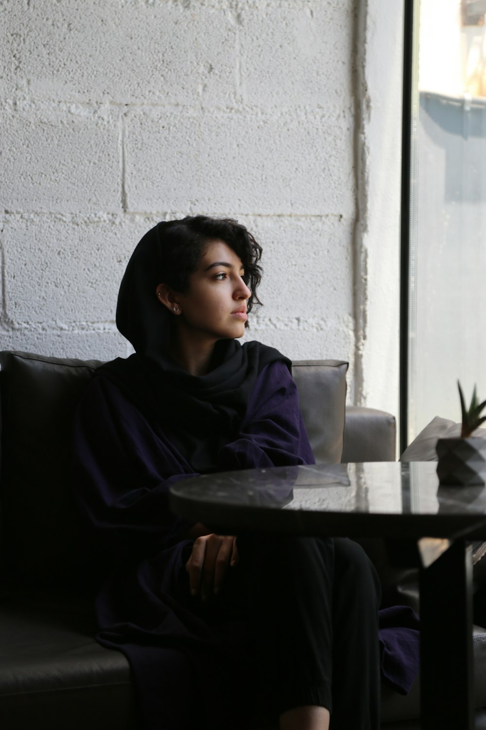 a woman sitting at a table in front of a window