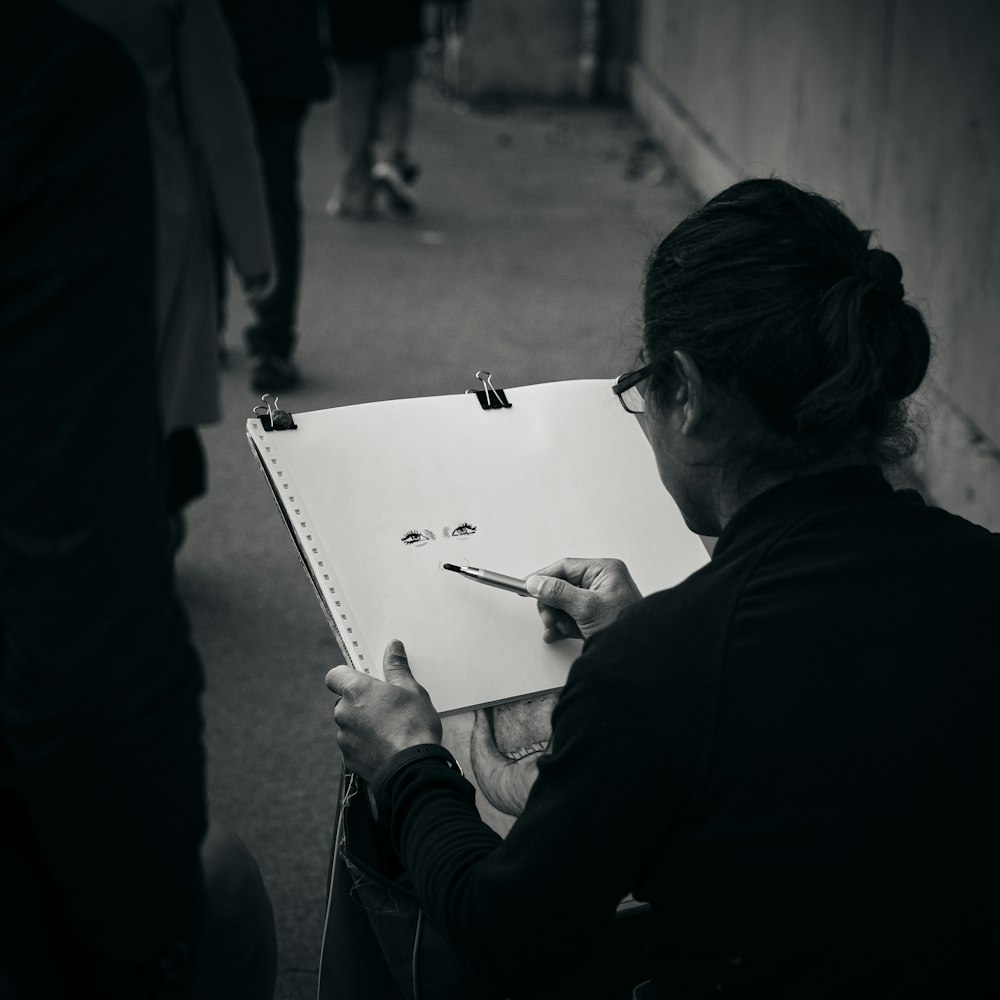 a woman is drawing on a piece of paper