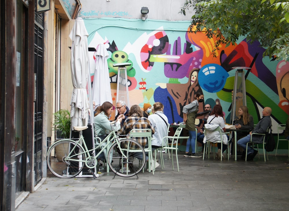 a group of people sitting at a table in front of a colorful wall