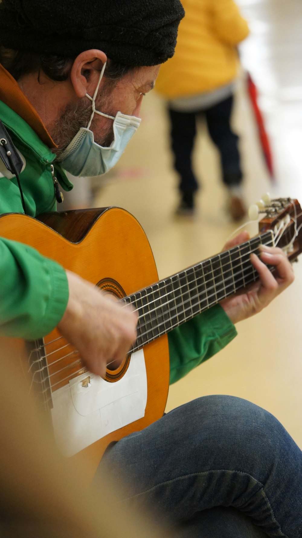 a man wearing a face mask playing a guitar