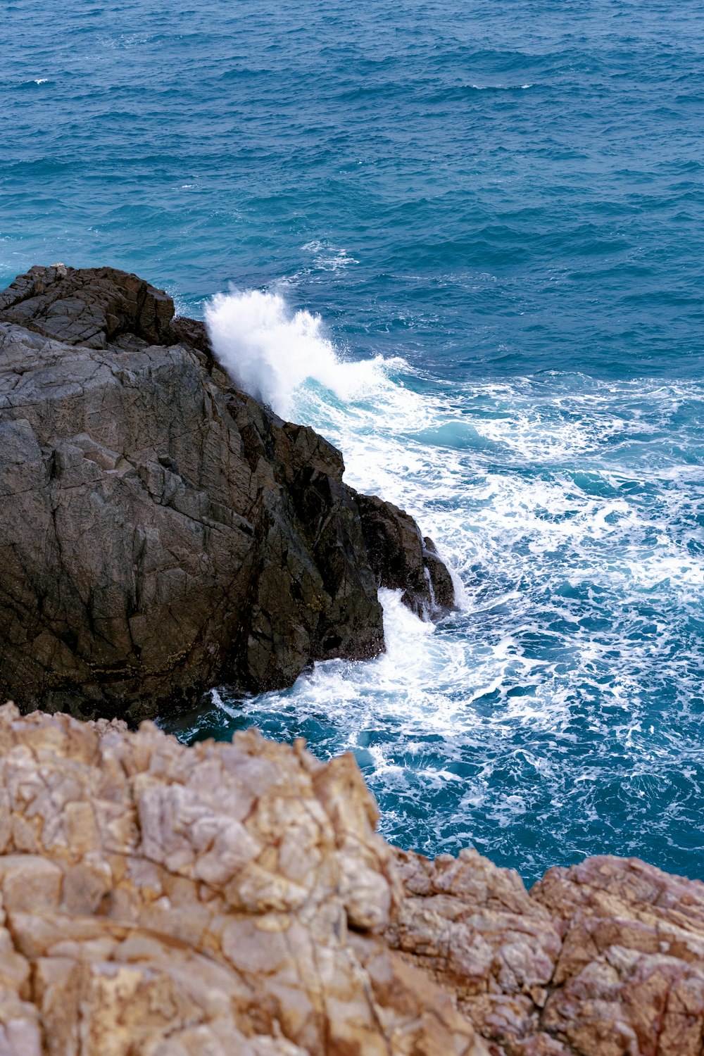 a person riding a surfboard on top of a large rock