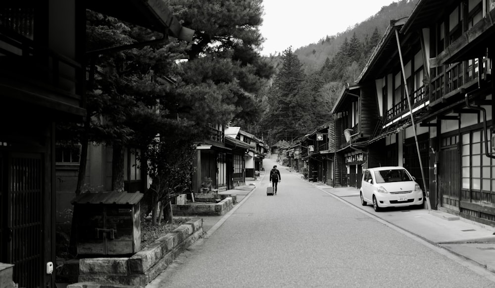 a man walking down a street next to tall buildings