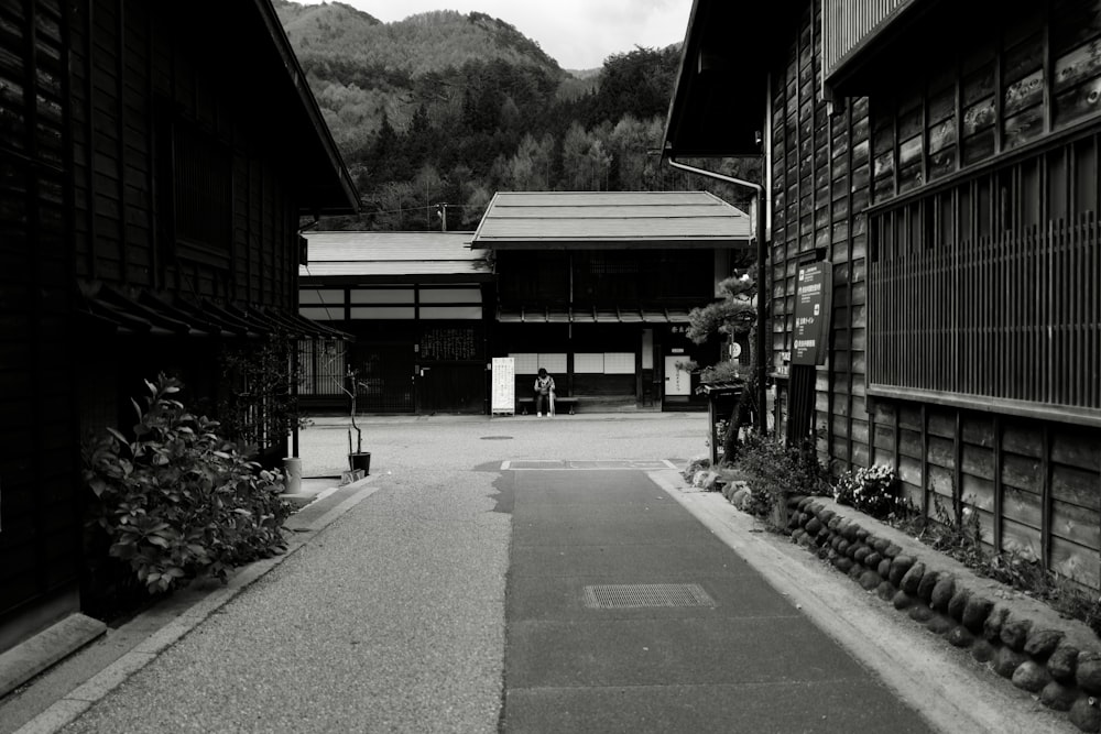 a black and white photo of a walkway between two buildings