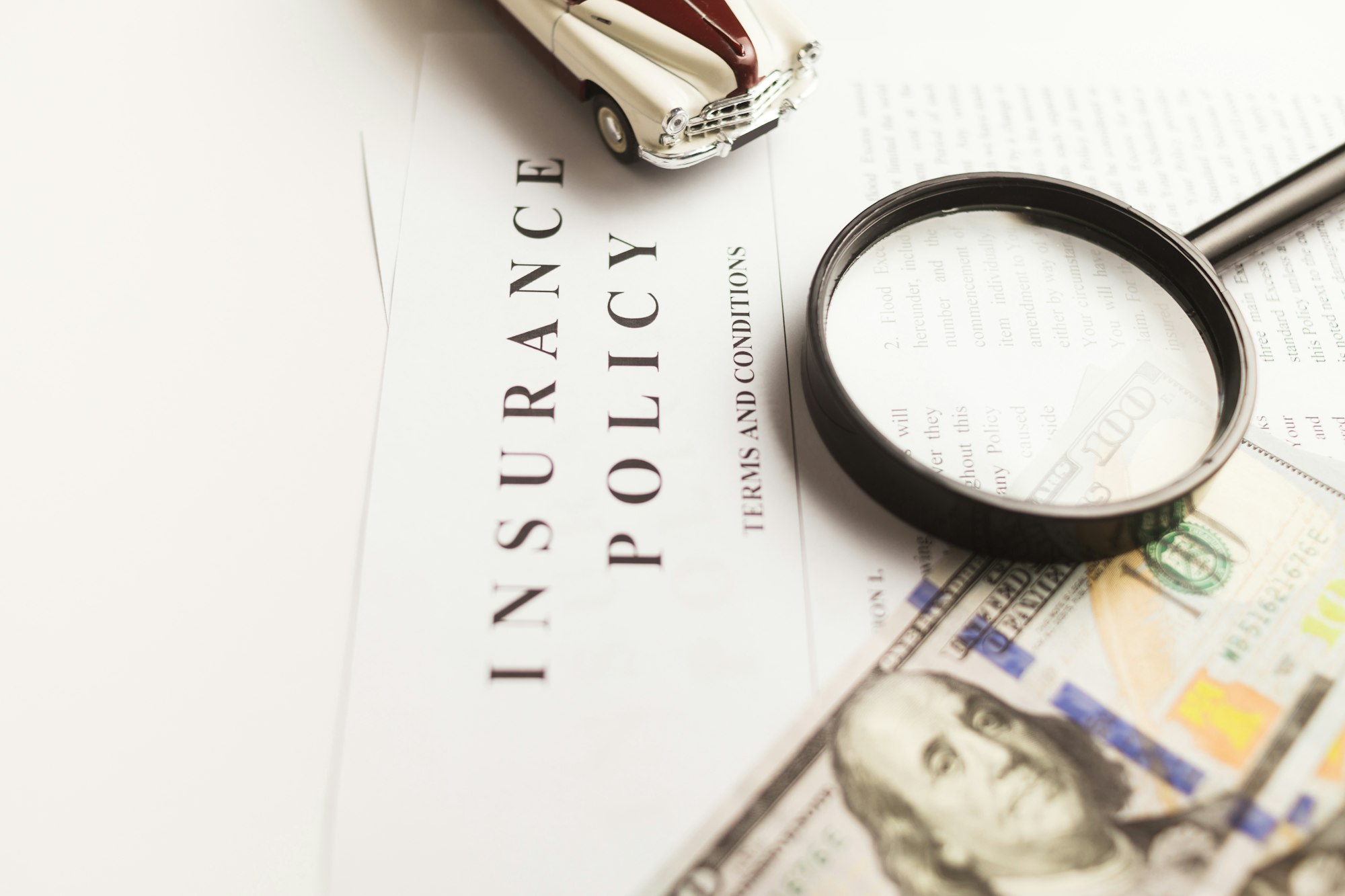 Certificate of motor insurance and policy with car and dollar bills.