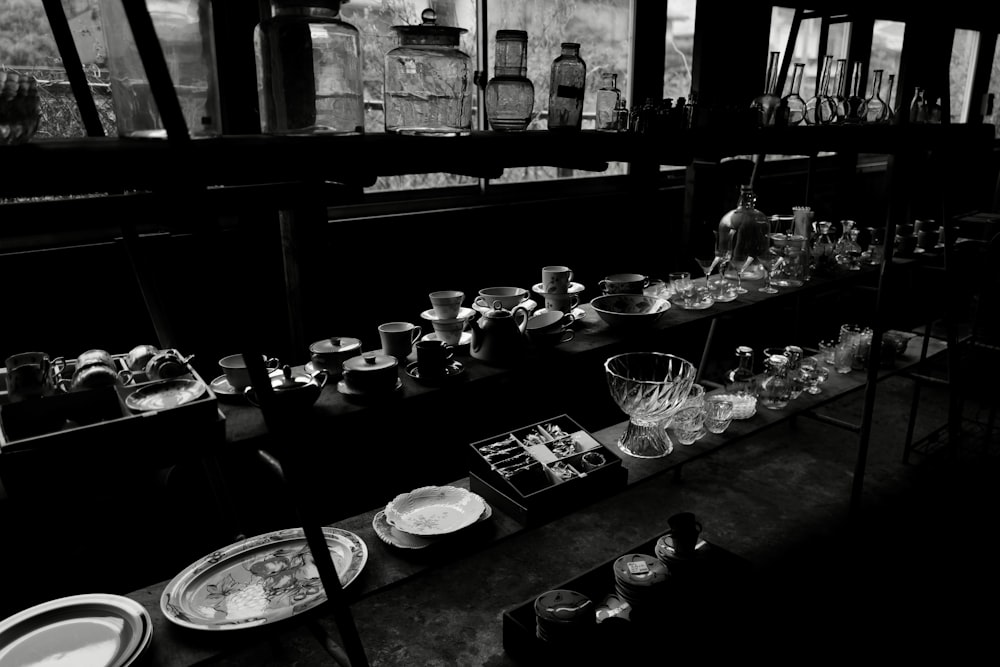 a black and white photo of a long table filled with dishes