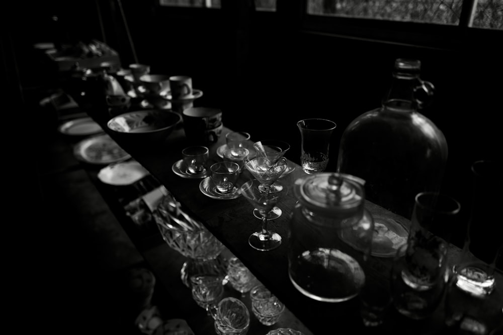 a black and white photo of wine glasses and bottles