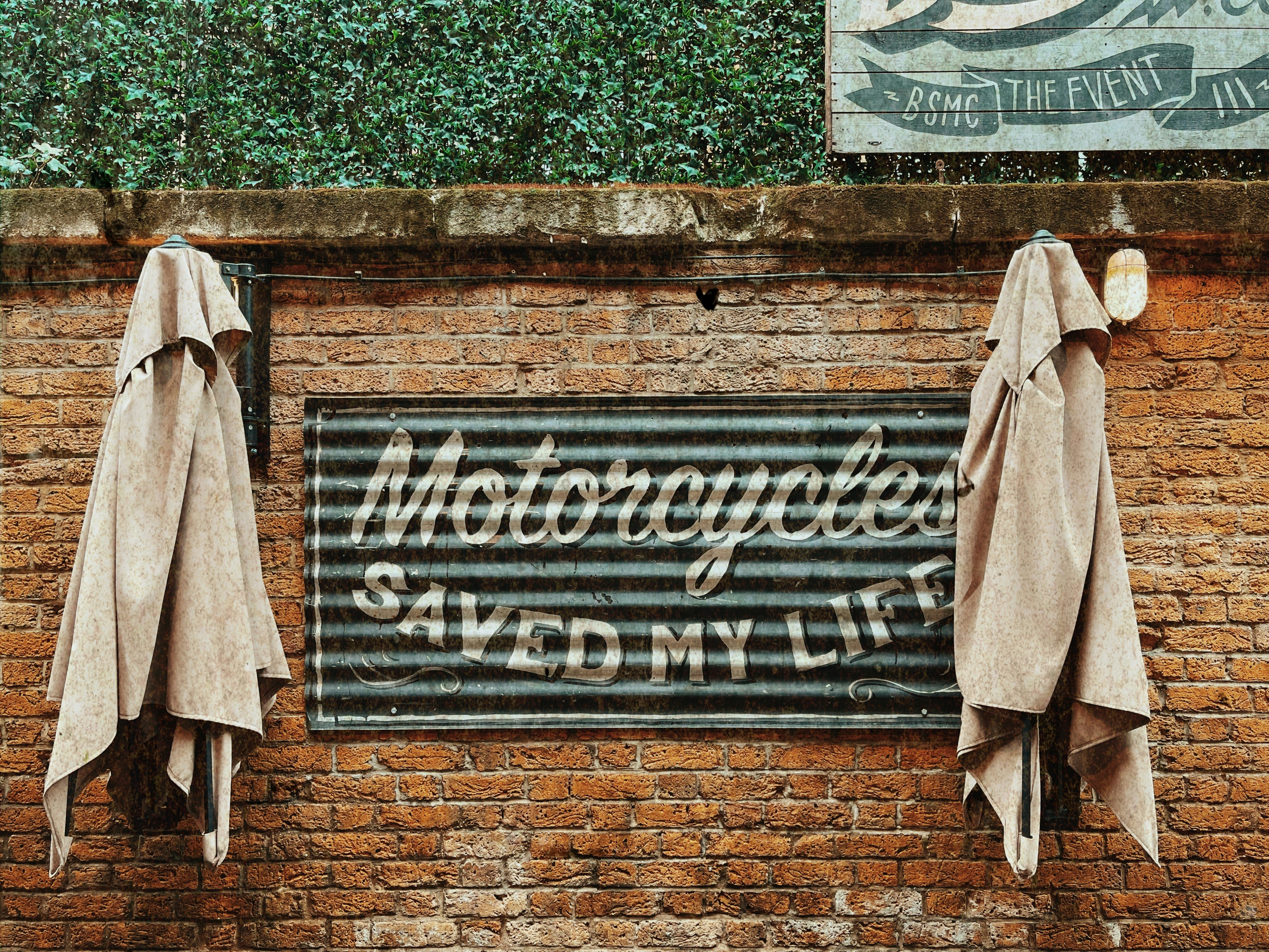 a brick wall with two umbrellas and a sign on it