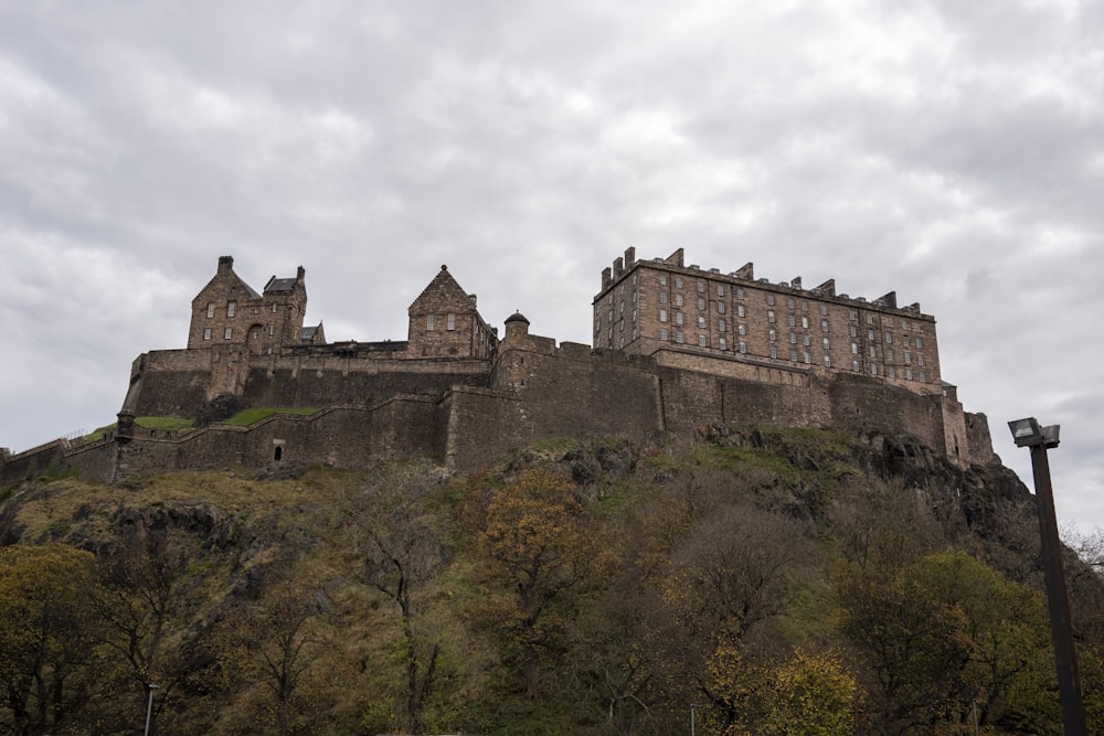 a castle on a hill with a cloudy sky