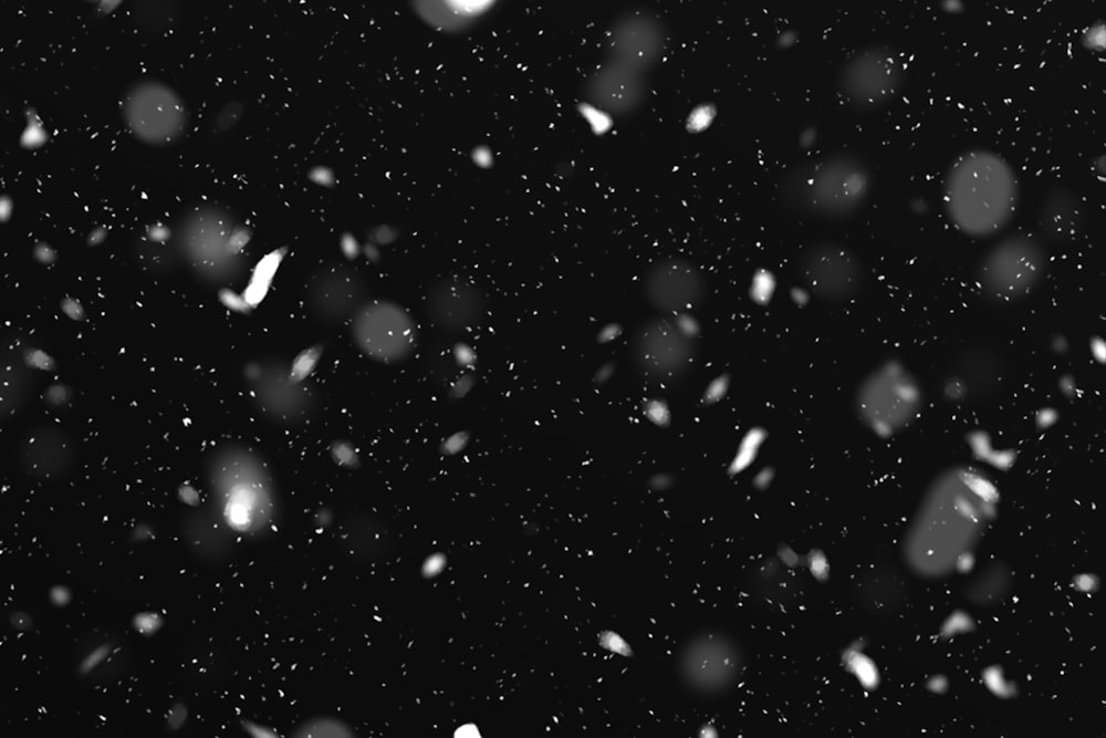 a black and white photo of snow falling