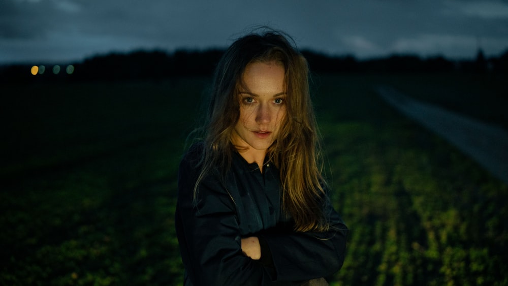 a woman standing in a field at night