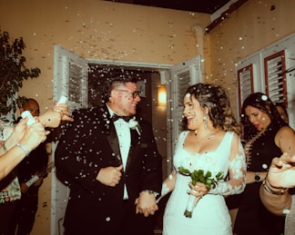 a bride and groom are walking through confetti