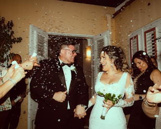 a bride and groom are walking through confetti