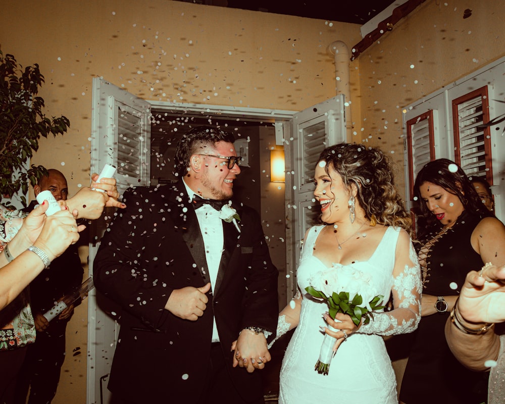a bride and groom are walking through confetti