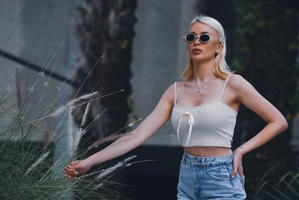 a woman wearing a crop top and denim shorts