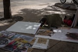a man is painting pictures on a sidewalk