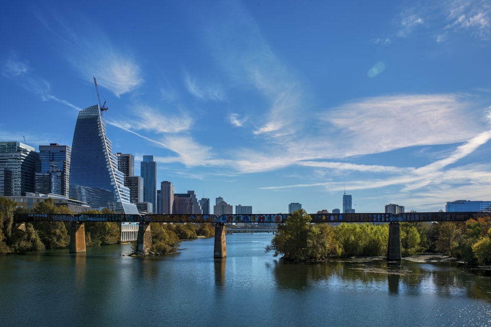 a bridge over a river with a city in the background