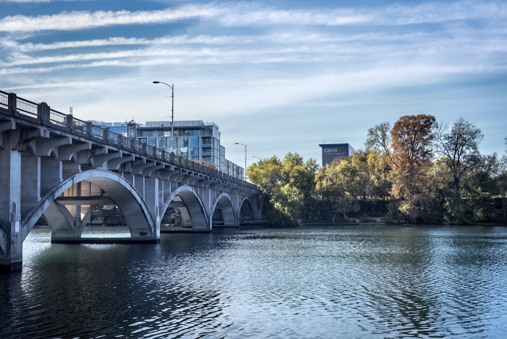 a bridge over a body of water with buildings in the background