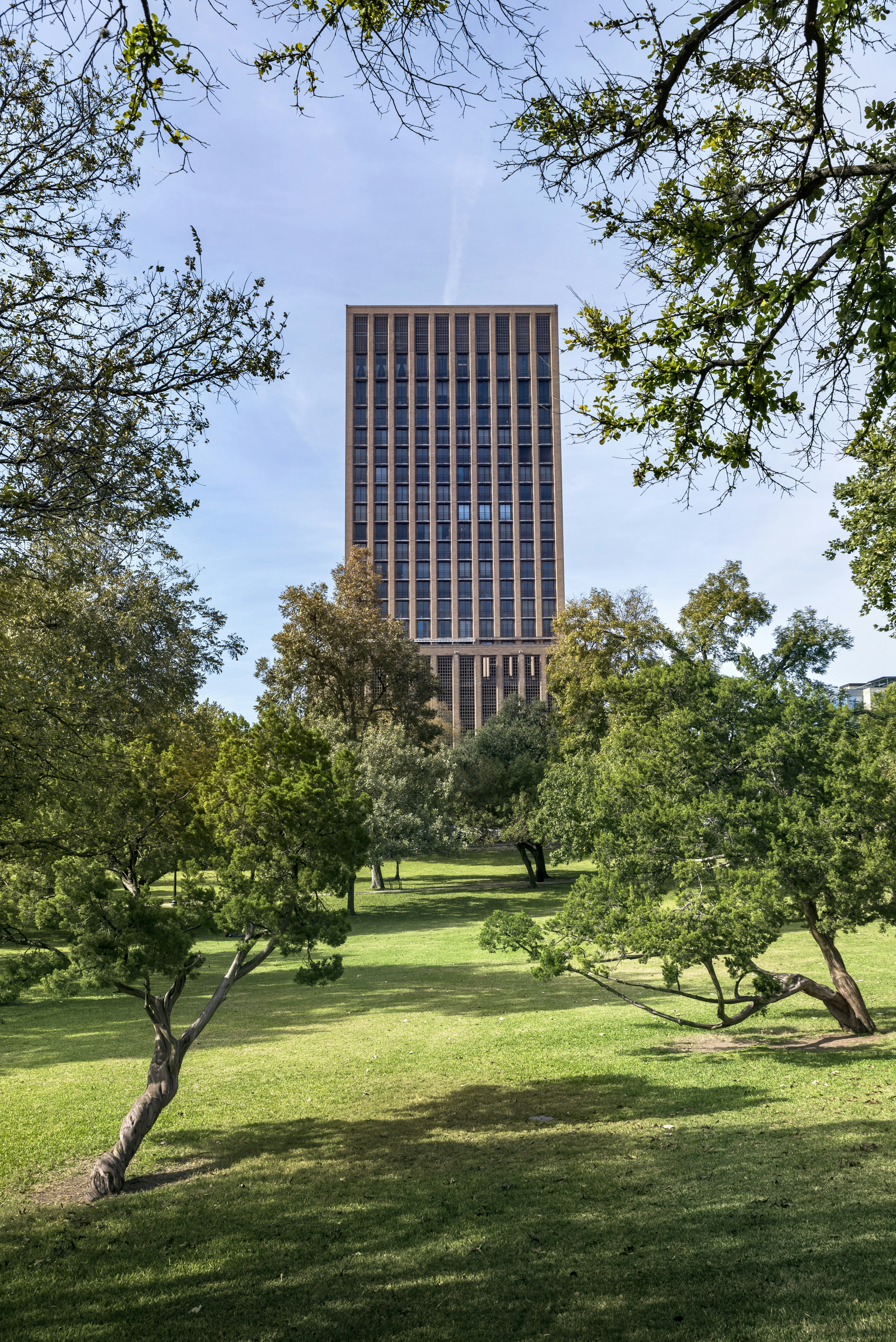 sebuah gedung tinggi yang terletak di atas taman hijau subur