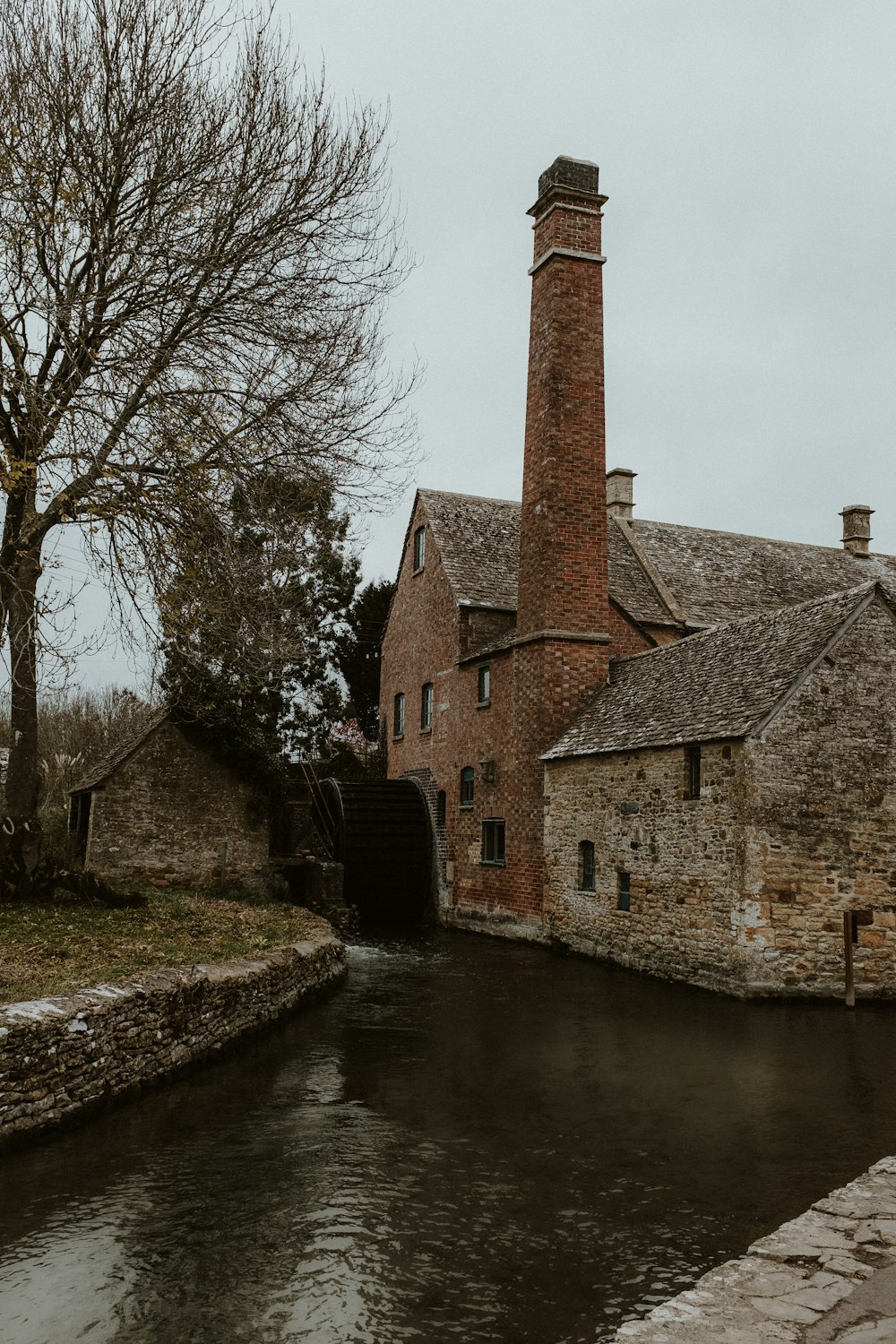 an old brick building next to a river