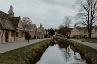 a river running through a village next to a road