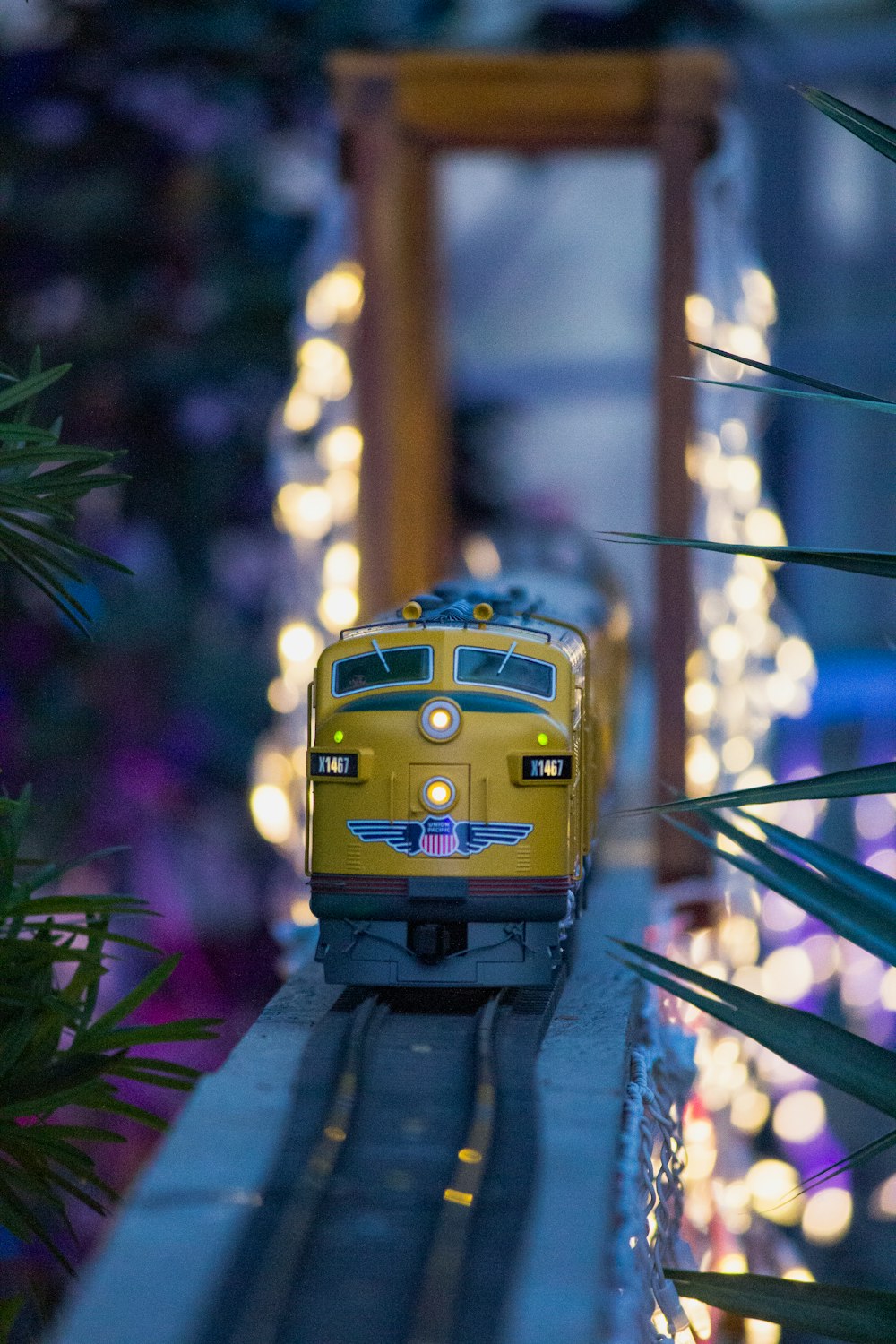 a yellow train traveling through a lush green forest