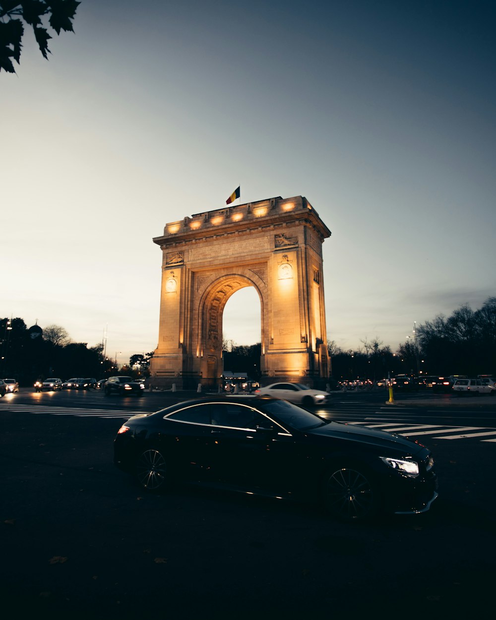 a car is parked in front of a large arch