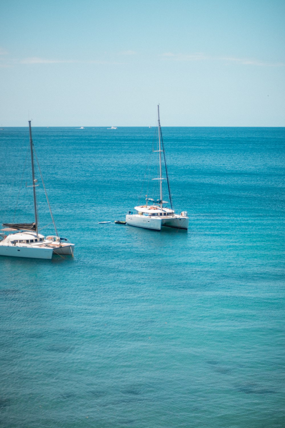 a couple of boats floating on top of a body of water