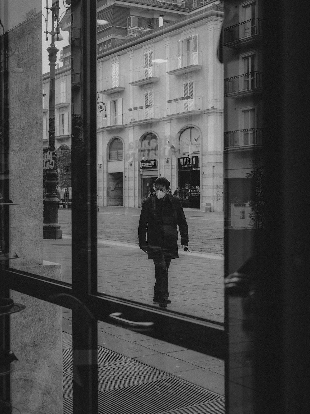 a man walking down a street next to a tall building