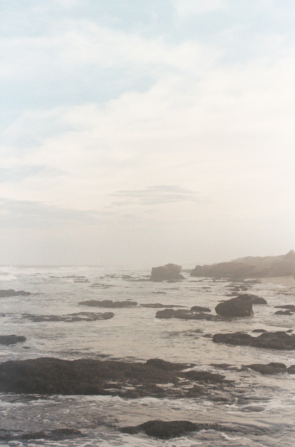 a person standing on a beach with a surfboard